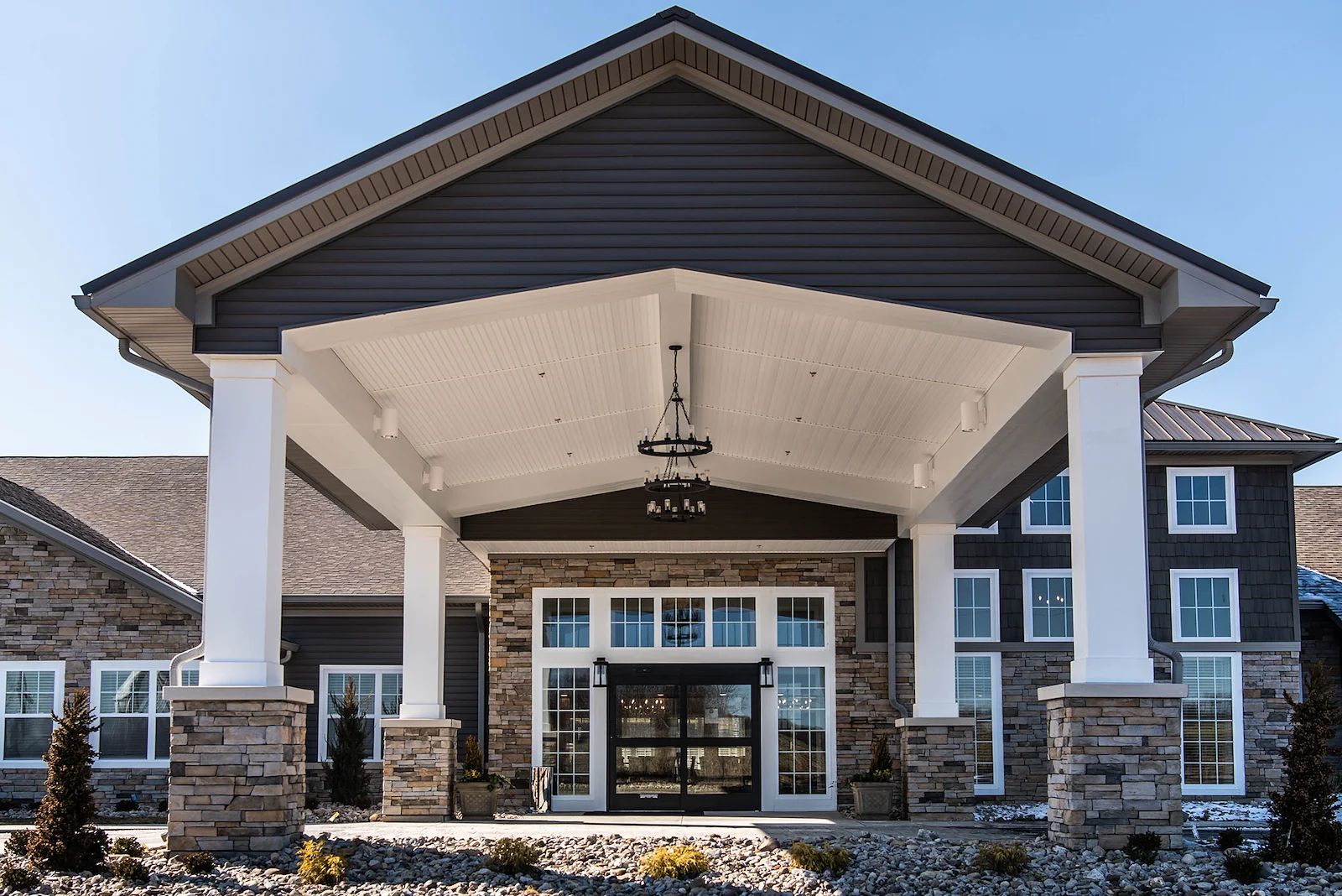 Charter Senior Living of Hopkinsville in Hopkinsville, KY, featuring a beautiful brick exterior, covered drive-through entrance, and grand front doors—offering expert assisted living and memory care services.